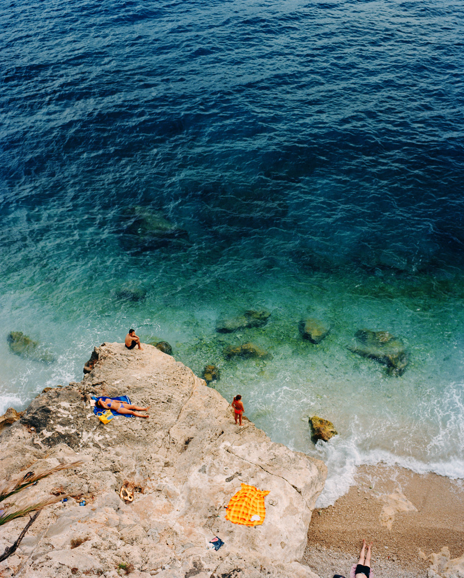 CROATIA, Dubrovnik, Dalmatian Coast, elevated view of group of people sunbathing by seashore