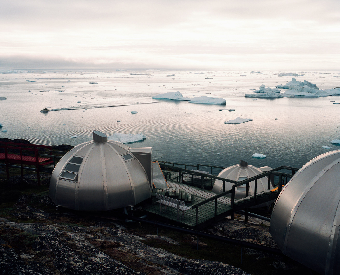 GREENLAND, Ilulissat, Disco Bay, elevated view of Hotel Arctic with icebergs and the sea in the background