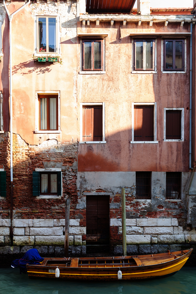 ITALY, Venice. View of a boat  parked in front of a home along a canal in the Castello district of Venice.