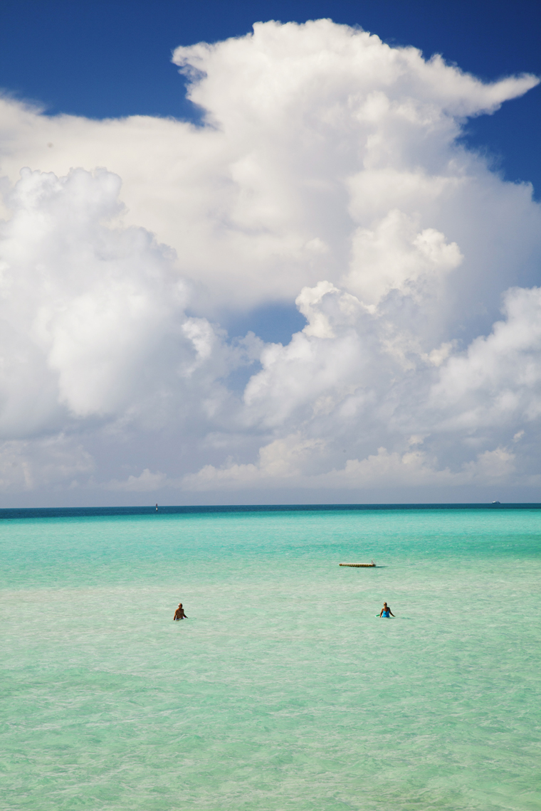 BERMUDA. Southampton Parish. A couple walking in the shallow water.